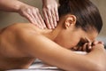 Massaging away all the worries and stress. a young woman enjoying a back massage at a spa. Royalty Free Stock Photo