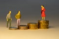 The masses looking to business woman standing on top of increasing piles of gold coins. Business career concept