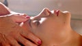 Masseur does head massage for pretty young woman in spa salon, close-up