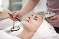 Masseur doing cream mask on face of beautiful young woman relaxing in the spa salon. Royalty Free Stock Photo