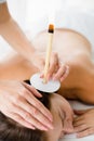 Masseur giving ear candle treatmet to woman Royalty Free Stock Photo