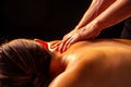 Masseur hands doing back panchakarma massage to client in spa center in dark room