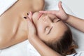 Masseur makes a relaxing massage on the face, neck, shoulders and collarbones of a young beautiful woman in a spa. Cosmetology and Royalty Free Stock Photo