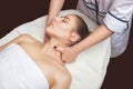 Masseur makes a relaxing massage on the face, neck, shoulders and collarbones of a young beautiful woman in a spa. Cosmetology and