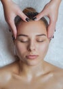 Masseur makes a relaxing massage on the face, neck, shoulders and collarbones of a young beautiful woman in a spa. Cosmetology and