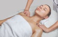 Masseur makes a relaxing massage on the face, neck, shoulders and collarbones of a young beautiful woman in a spa. Cosmetology and Royalty Free Stock Photo