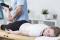 Masseur massaging female customer's leg