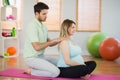 Masseur massaging shoulders of pregnant woman