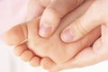 Masseur massaging a small childrens foot. Mother is doing massage on her baby foot.