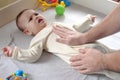 Masseur massaging the tummy of the baby during colic. Mother massaging infant belly, kid laughing Royalty Free Stock Photo