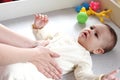 Masseur massaging the tummy of the baby during colic. Mother massaging infant belly, kid laughing Royalty Free Stock Photo