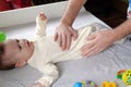 Masseur massaging the tummy of the baby during colic. Mother massaging infant belly, kid laughing Royalty Free Stock Photo