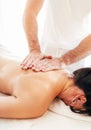 Masseur man doing massage manipulations on the scapula area zone during massaging female body Royalty Free Stock Photo