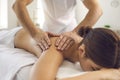 Hands of professional chiropractor or masseur making massage of back and shoulders for woman