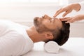 Masseuse hands rubbing sleeping middle-aged man forehead, closeup Royalty Free Stock Photo