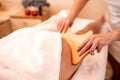 Masseuse holding a hand held wooden massage tool