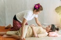 Masseuse woman therapy massage young girl at spa salon. Beautiful young woman lying on the pillow receiving masseuse