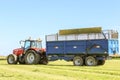 Massey Ferguson tractor pulling a trailer in grass field Royalty Free Stock Photo