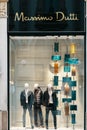 Massimo Dutti logo and showcase of luxury fashion shop in Milan. Three male mannequins standing in store display. Milan