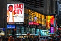 Massive advertising Billboards tower above traffic and pedestrians at the intersection between Times Square and Broadway.