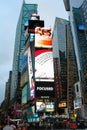 Massive advertising screens tower above pedestrians in Times Square