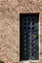 Massive antique outside wooden door of a chateau, castle with many small square windows Royalty Free Stock Photo