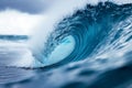 A massive blue wave crashes forcefully as it breaks into the vast ocean, An ocean wave captured at the precise moment it curls