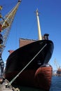 The massive bow of a large ship, with the radar dome above the surface of the water with crane, at the seaport. vertical. Royalty Free Stock Photo