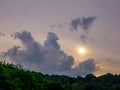 Massive cloud over the hill and the sun obscured by a layer of clouds early in the morning Royalty Free Stock Photo