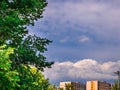 Massive clouds above the houses in the distance on the blue sky