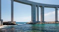 Massive coastal bridge over turquoise waters with rocky shoreline Royalty Free Stock Photo