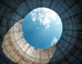 Massive concrete structure of cooling tower looking up at bright blue sky with white clouds. Industrial scale engineering Royalty Free Stock Photo