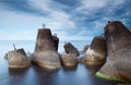 Massive concrete tetrapods form a breakwater with soft blur sea