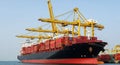 Massive Container Ship Docked at Port with Yellow Gantry Cranes Loading Cargo ship Royalty Free Stock Photo