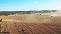 Massive field with multiple combines reaping wheat