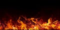 Massive fire burning in darkness. Seamless border with flame on a black background for banner. Red, orange, yellow Royalty Free Stock Photo