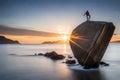 A massive granite boulder precariously balanced on the edge of a rocky cliff, defying gravity