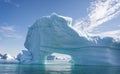 Massive iceberg with arch and beautiful aquamarine coloured ice and sea in Disko Bay, Greenland Royalty Free Stock Photo