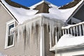 Hanging icicles hang from a two story roof