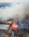 Massive large blaze fire in the city, aerial drone top view brick factory building on fire, hell major fire explosion flame blast