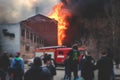 Massive large blaze fire in the city, brick factory building on fire, hell major fire explosion flame blast, with firefighters