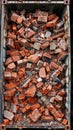Close-up view of a metal container overflowing with bricks and debris from a demolished building Royalty Free Stock Photo