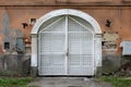 Massive old wooden entrance doors secured with strong metal frame locked with padlock mounted on cracked dilapidated destroyed Royalty Free Stock Photo