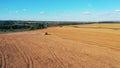 Massive rye field with a reaping combine riding along it