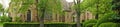 Panorama large gothic stone building framed by greenery Royalty Free Stock Photo