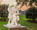 Massive traditional urban park gypsum sculpture of the times of the USSR. Mother reads a book to her daughter