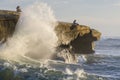 Massive wave crashing on cliff below people at Sunset Clifss