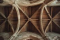 massive wooden beams beneath the vaulted ceilings of an ancient cathedral.