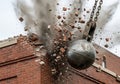 Massive Wrecking Ball Hits Brick Building Corner Creating Explosion of Debris. Royalty Free Stock Photo