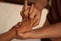 Massotherapist stretching patient digits during Thai massage session